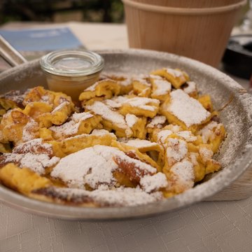 Neuigkeiten aus dem Motorradhotel in Tirol Kaiserschmarrn mit Puderzucker in Pfanne serviert