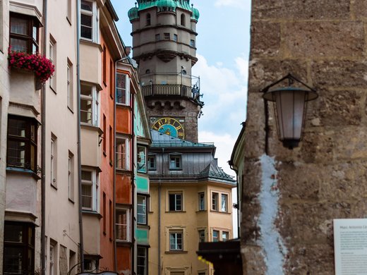 Hotel per conferenze vicino a Innsbruck Parkhotel Matrei Torre storica con tetto verde tra case colorate in una stretta via