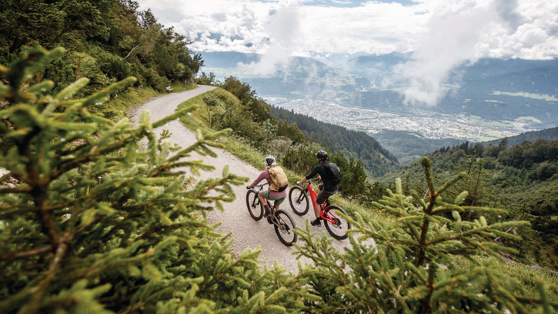 Parkhotel Matrei: Mountainbikehotel in Tirol Zwei Radfahrer auf einem Bergweg mit Blick auf Tal und Wolken