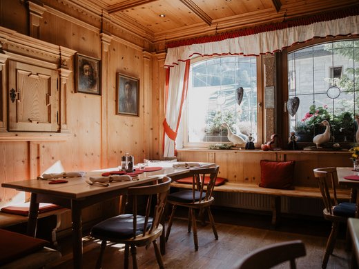 Benvenuti al nostro hotel a Matrei Interno accogliente in legno con decorazioni sulla finestra in una sala da pranzo tradizionale.