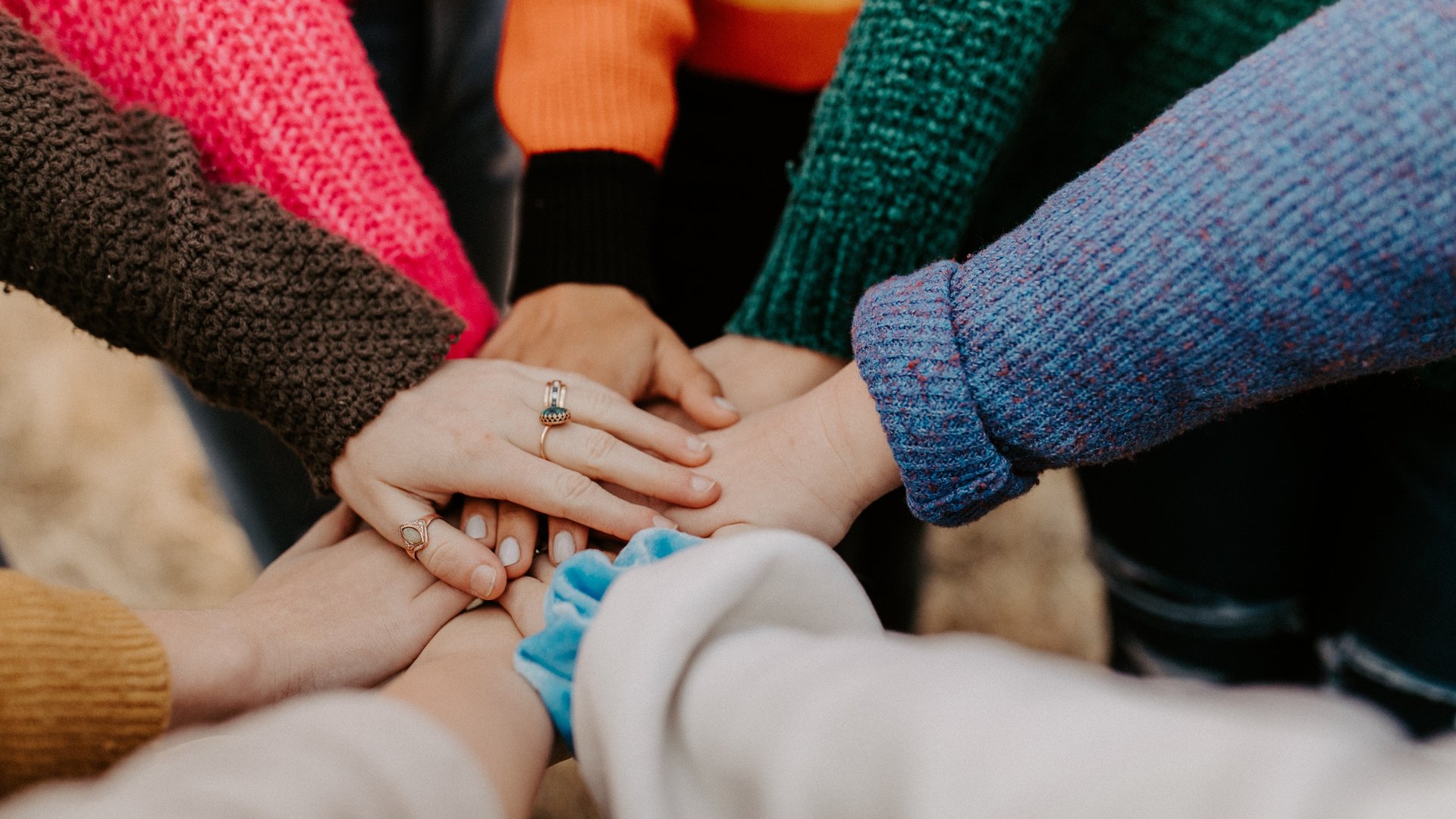 Multiple hands stacked together symbolizing teamwork