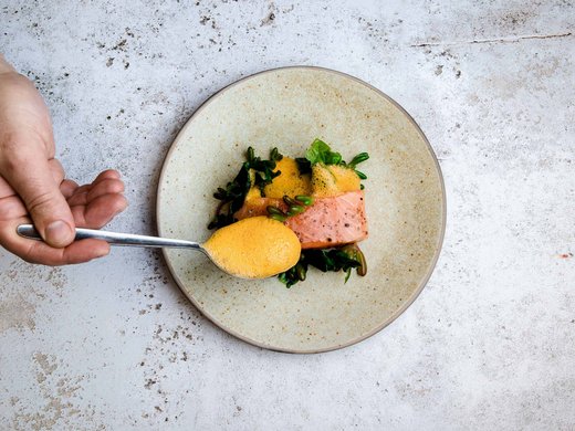 Hotel vicino all’Autostrada del Brennero: comodo e bello Cucchiaio con salsa gialla sopra salmone e verdure su piatto