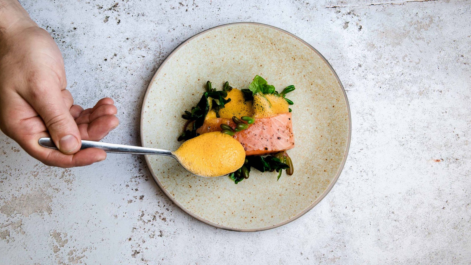 Eventi e feste al Parkhotel Matrei Cucchiaio con salsa gialla sopra salmone e verdure su piatto