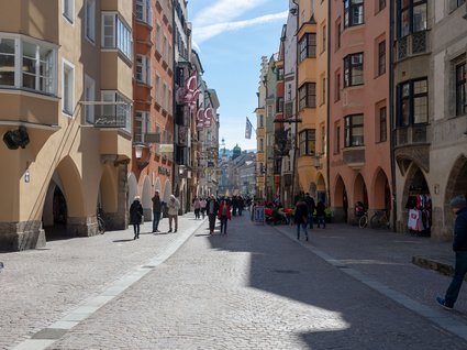 Ausflugstipps aus unserem Hotel: Innsbruck und Umgebung Fußgängerzone mit bunten Gebäuden im historischen Stadtzentrum bei sonnigem Wetter