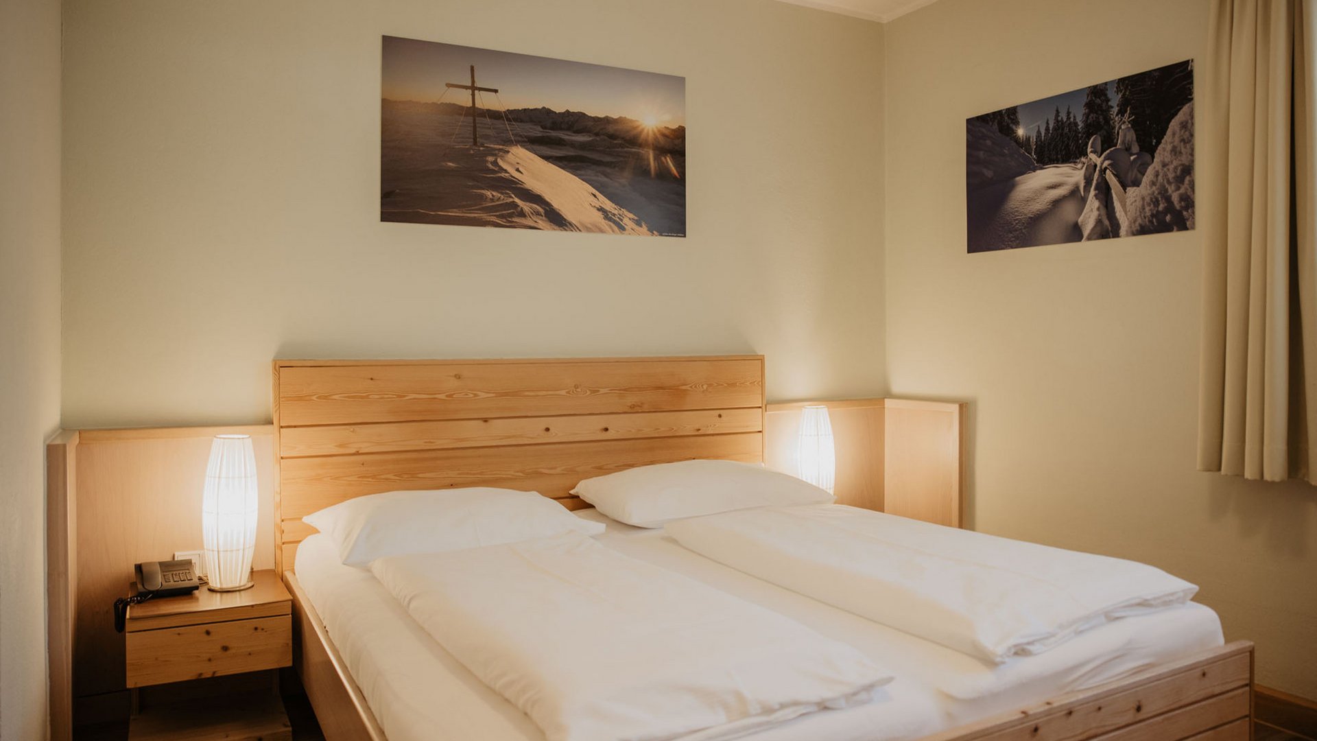 Vacanza in Tirolo: le nostre camere Camera d'albergo accogliente con letto matrimoniale e cornice in legno