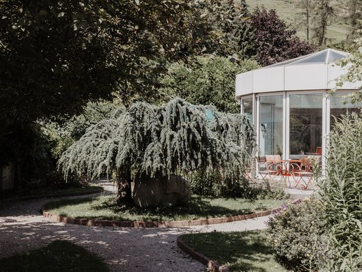 Zentrales und gemütliches Hotel am Brenner | Parkhotel Matrei Gepflegter Garten mit einzigartigem Baum und Terrasse neben einem Glaspavillon