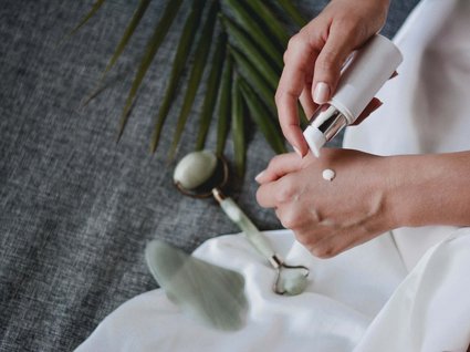 Das etwas andere Hotel in Tirol mit Wellnessbereich Person trägt Creme auf Handrücken auf, Hautpflegewerkzeuge liegen daneben
