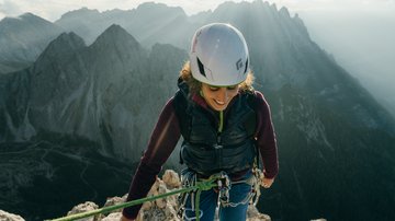 News (Liste) Klettererin mit Helm am Berg bei Sonnenlicht