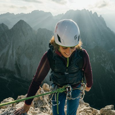 News (Liste) Klettererin mit Helm am Berg bei Sonnenlicht