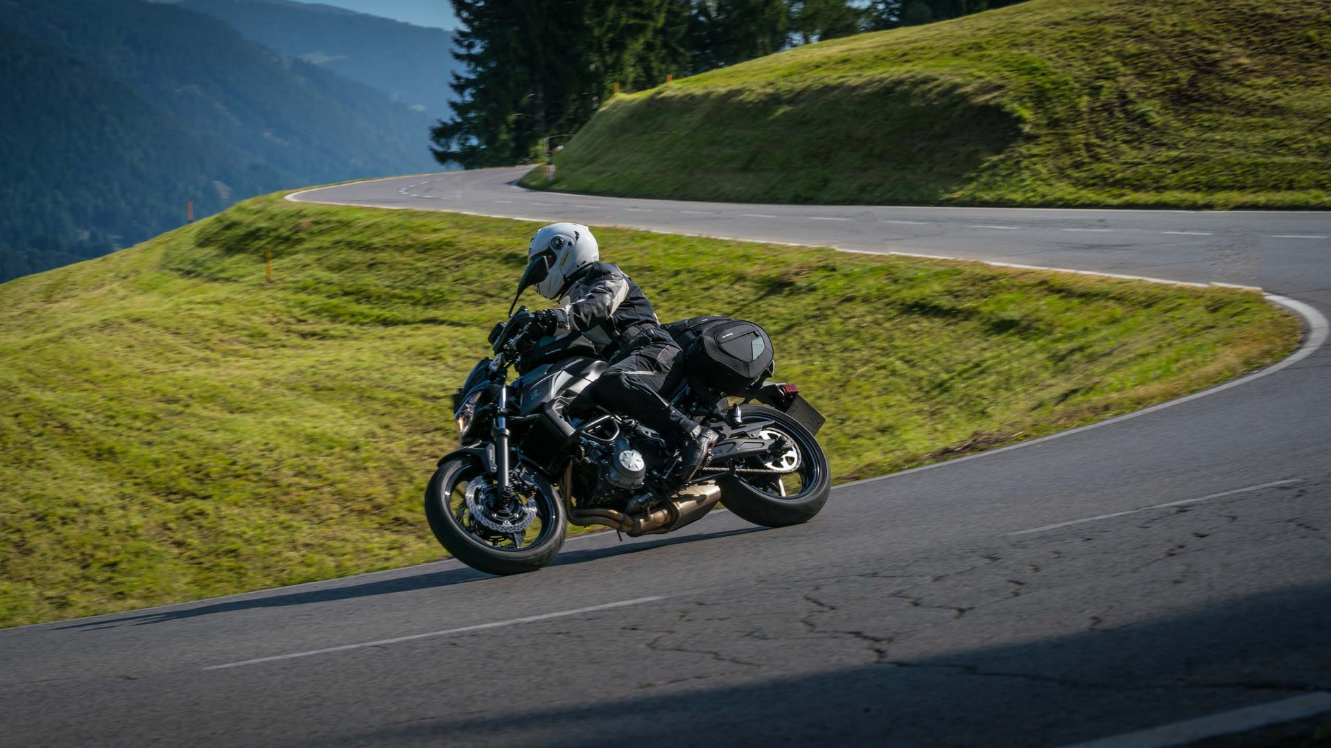 Mobilità e MTB nello Stubai Motociclista con abbigliamento protettivo su strada di montagna curva