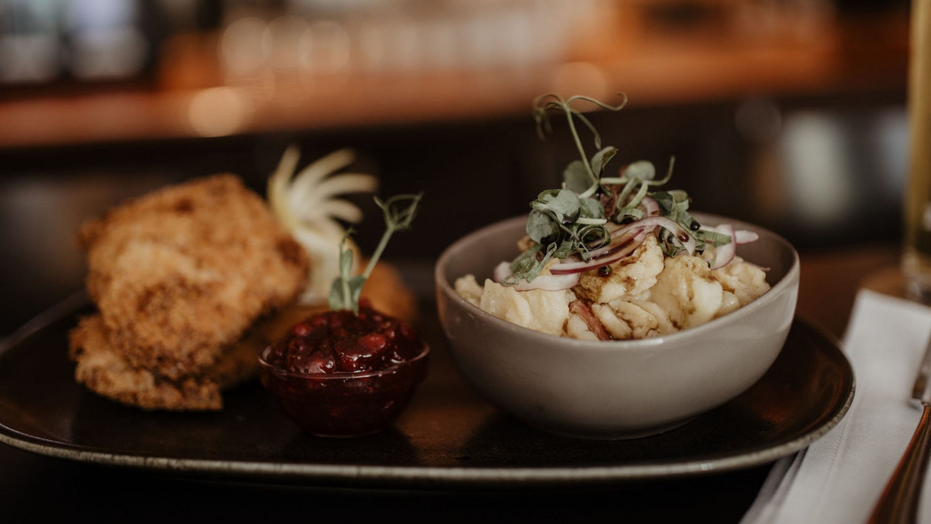 Kurzurlaub in Tirol? Ja, bitte! Bayerisches Gericht mit Schnitzel, Kartoffelsalat und Bier im Restaurant