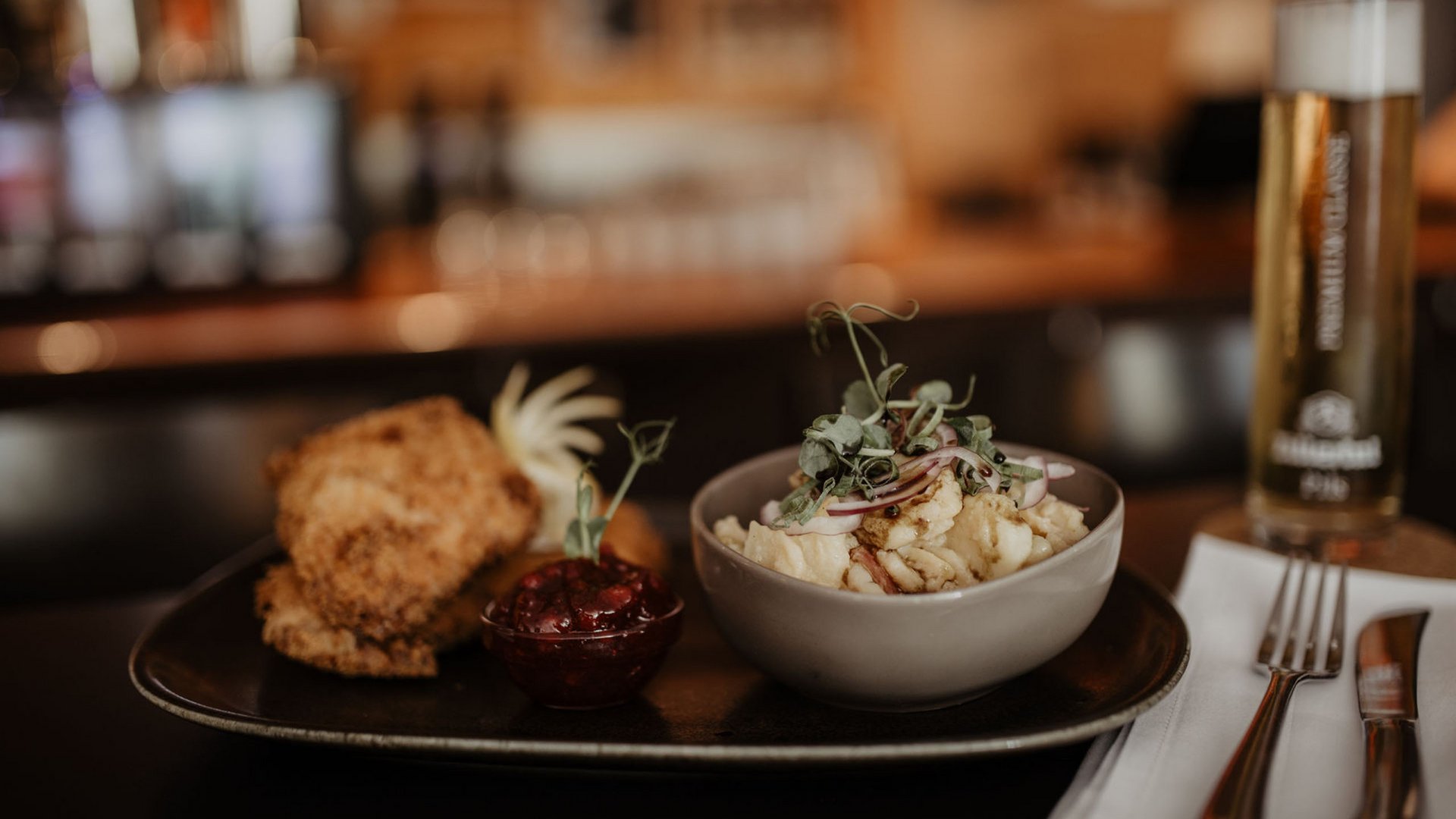 Bayerisches Gericht mit Schnitzel, Kartoffelsalat und Bier im Restaurant