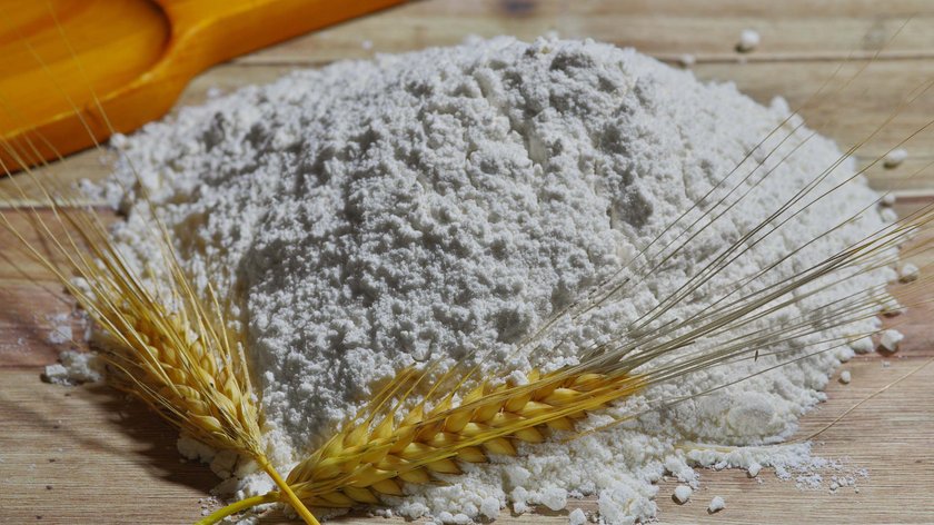 Rezept für Tiroler Kiachel Haufen Weizenmehl mit zwei Ähren auf Holzuntergrund