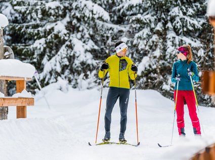 Settimana bianca nel comprensorio dello Stubai e altro Coppia che fa sci di fondo in un bosco innevato
