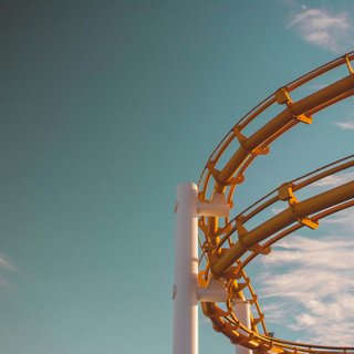 News (Teaser) Gelbe Achterbahnstruktur vor blauem Himmel mit Wolken