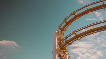 News (Liste) Gelbe Achterbahnstruktur vor blauem Himmel mit Wolken