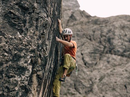 Hiking in Matrei am Brenner Man climbing a steep rock wall in the mountains