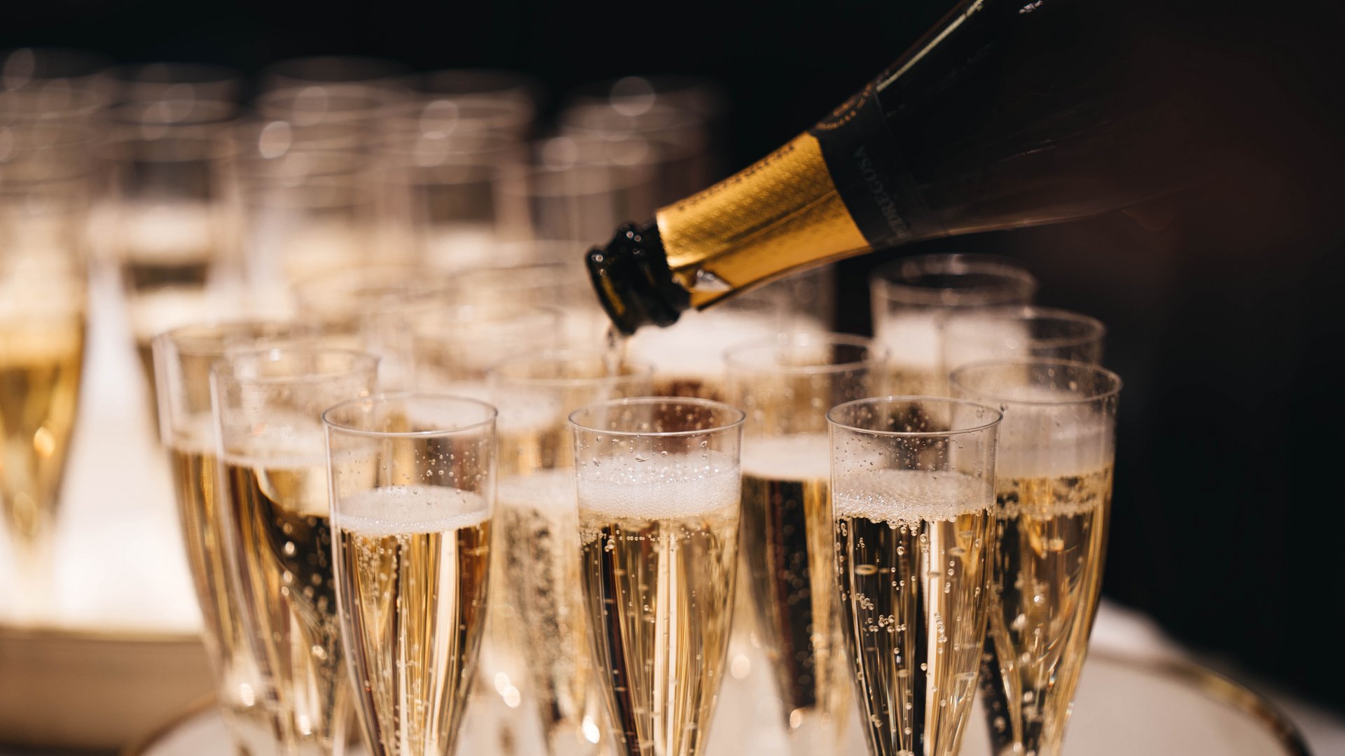 Champagne versata in molti flute su un vassoio