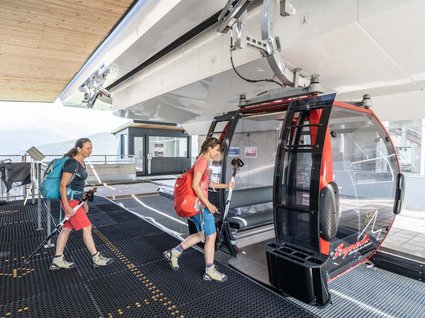 Wanderhotel in Tirol: herrliche Berge und Täler Zwei Wanderinnen steigen in eine Gondelbahn ein