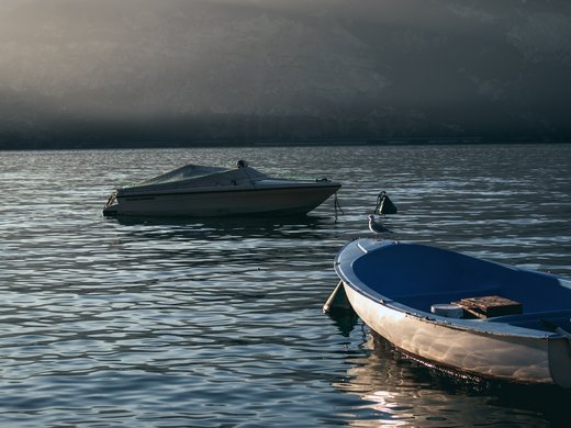 Hotel vicino all’Autostrada del Brennero: comodo e bello Due barche sull'acqua calma al tramonto con montagne sullo sfondo