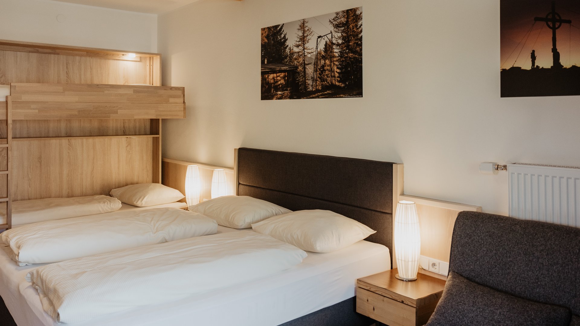 Your first choice for an overnight stay in Matrei am Brenner Cozy bedroom with double bed, bunk bed, and warm lighting