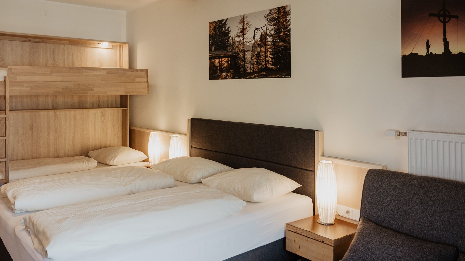 Herzlich willkommen in unserem Hotel in Matrei am Brenner Gemütliches Schlafzimmer mit Doppelbett, Stockbett und warmen Lampen