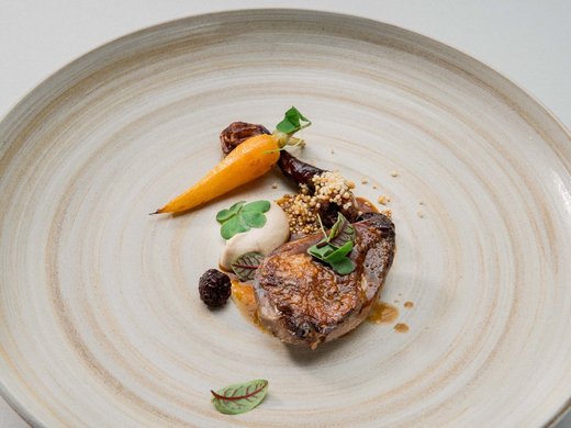 Genuss vorbestimmt im Restaurant in Matrei am Brenner Fein angerichtetes Gericht mit gebratenem Fleisch, Karotte und Kräutern auf Teller