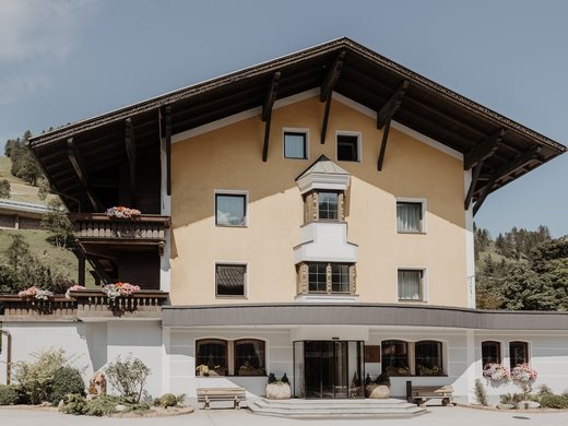 Zentrales und gemütliches Hotel am Brenner | Parkhotel Matrei Traditionelles Alpenhaus mit Blumen und Balkon in malerischer Landschaft