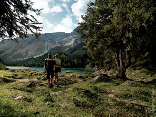 Ausflugstipps aus unserem Hotel: Innsbruck und Umgebung Paar wandert an einem See in den Bergen bei sonnigem Wetter