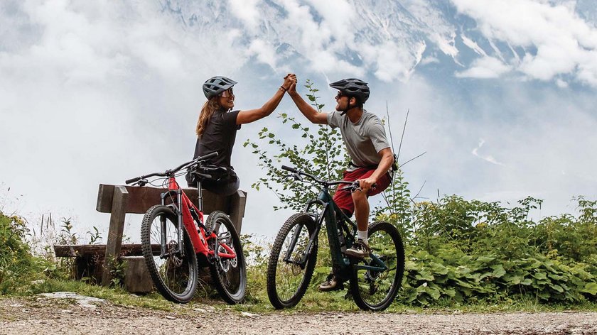 Der 559 Kreuzweg im Stubaital Zwei Radfahrer in Berglandschaft geben sich High Five