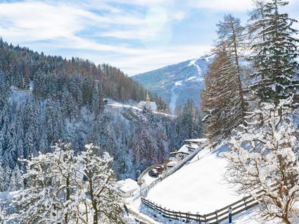 Attrazioni ed escursioni in Tirolo, Austria Paesaggio invernale innevato con boschi, montagne e case sotto il sole