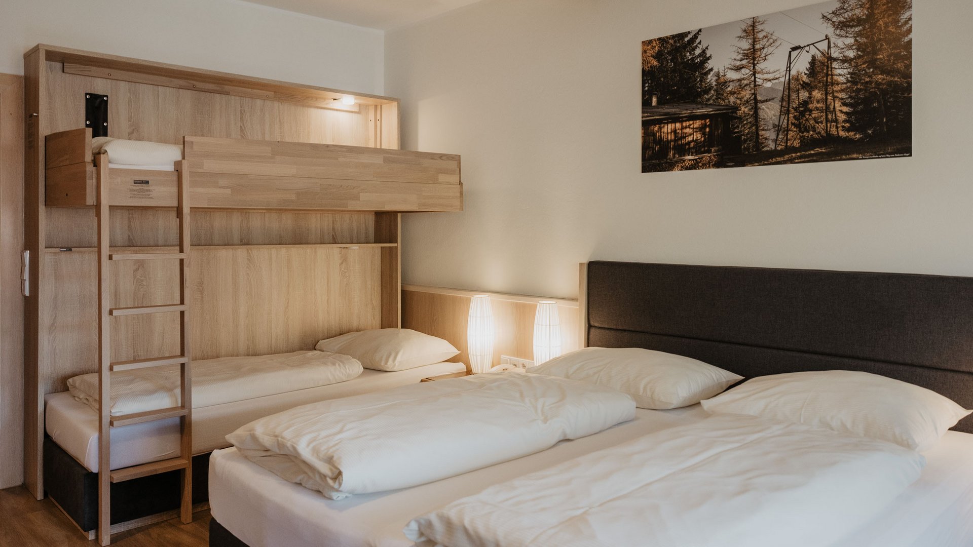 Benvenuti al nostro hotel a Matrei Camera d'albergo con letto matrimoniale, letto a castello e illuminazione moderna