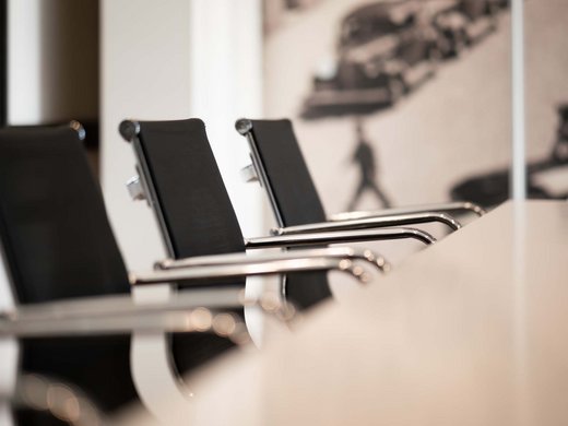 Hotel con sala meeting in Austria Sedie da ufficio nere attorno a un tavolo bianco in uno spazio moderno