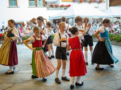 Attrazioni ed escursioni in Tirolo, Austria Bambini ballano in costumi tradizionali durante una festa con pubblico