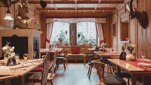 Benvenuti al nostro hotel a Matrei Ristorante accogliente con tavoli in legno e decorazioni tradizionali