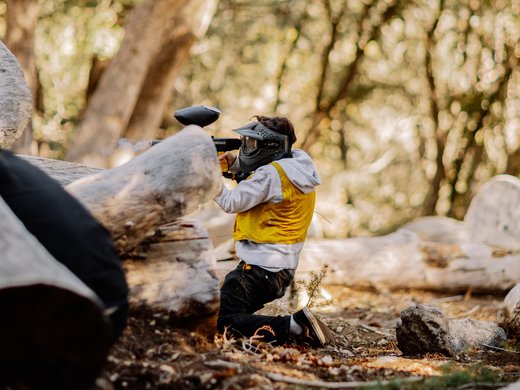 Hotel per conferenze vicino a Innsbruck Parkhotel Matrei Persona in ginocchio che gioca a paintball con maschera protettiva nel bosco