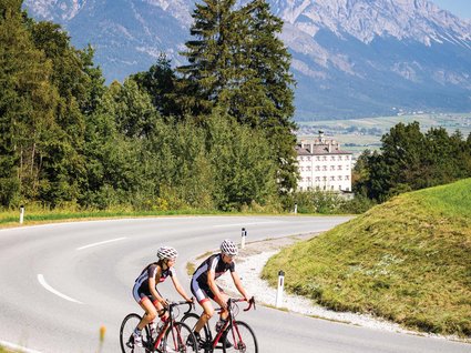 Parkhotel Matrei: Mountainbikehotel in Tirol Zwei Radfahrer auf Bergstraße mit Alpen im Hintergrund