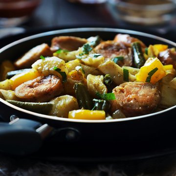 Neuigkeiten aus dem Motorradhotel in Tirol Gebratene Bratwurst mit Gemüse in einer Pfanne