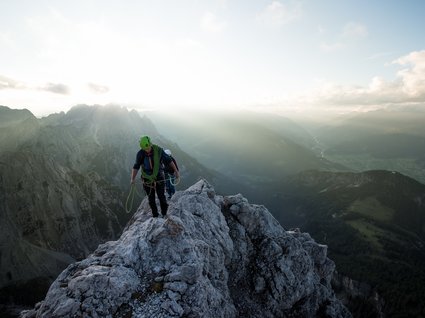Holidays at the Brenner Pass: hiking and climbing Climbers with helmets and ropes on rocks at sunset in the mountains